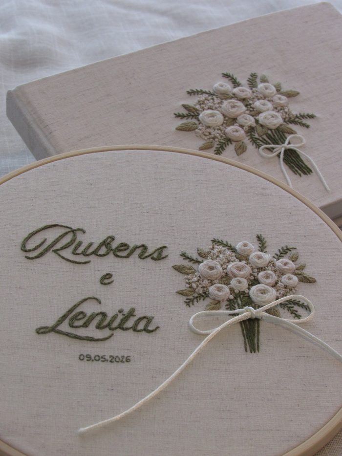 Porta-alianças em bastidor: Rubens e Lenita, buquê bordado e a data 09.05.2026